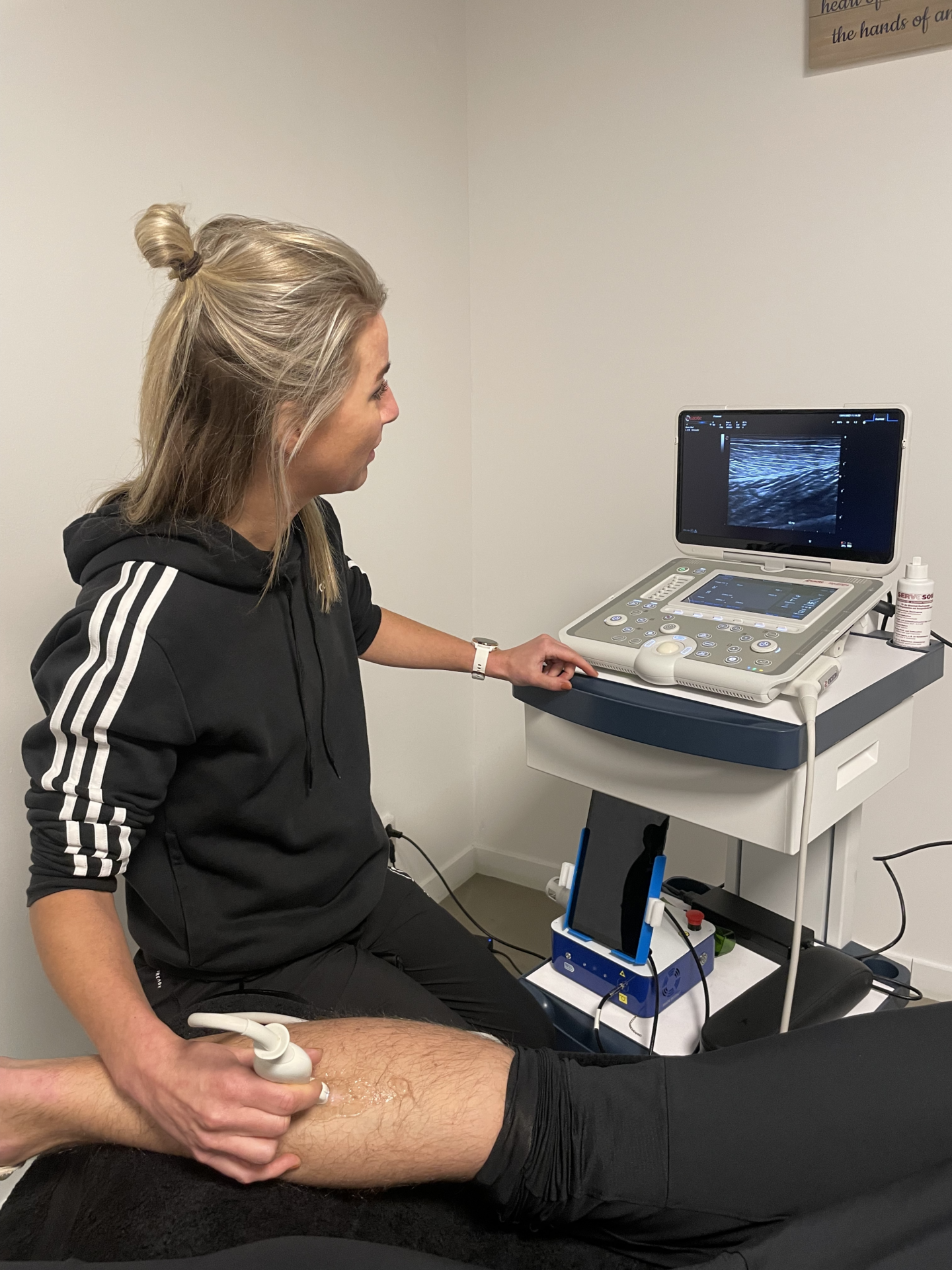 Fysiotherapeut van Fysio Zorg op Maat voert echografie behandeling uit patiënt met echografie apparaat.